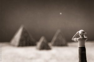 Figurine of a man looking towards miniature pyramids.