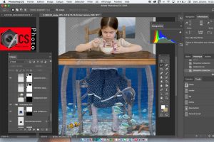 Vue d'un écran d'ordinateur avec le programme Photoshop de traitement numérique des images et une photo surréelle d'une enfant qui mange une soupe.