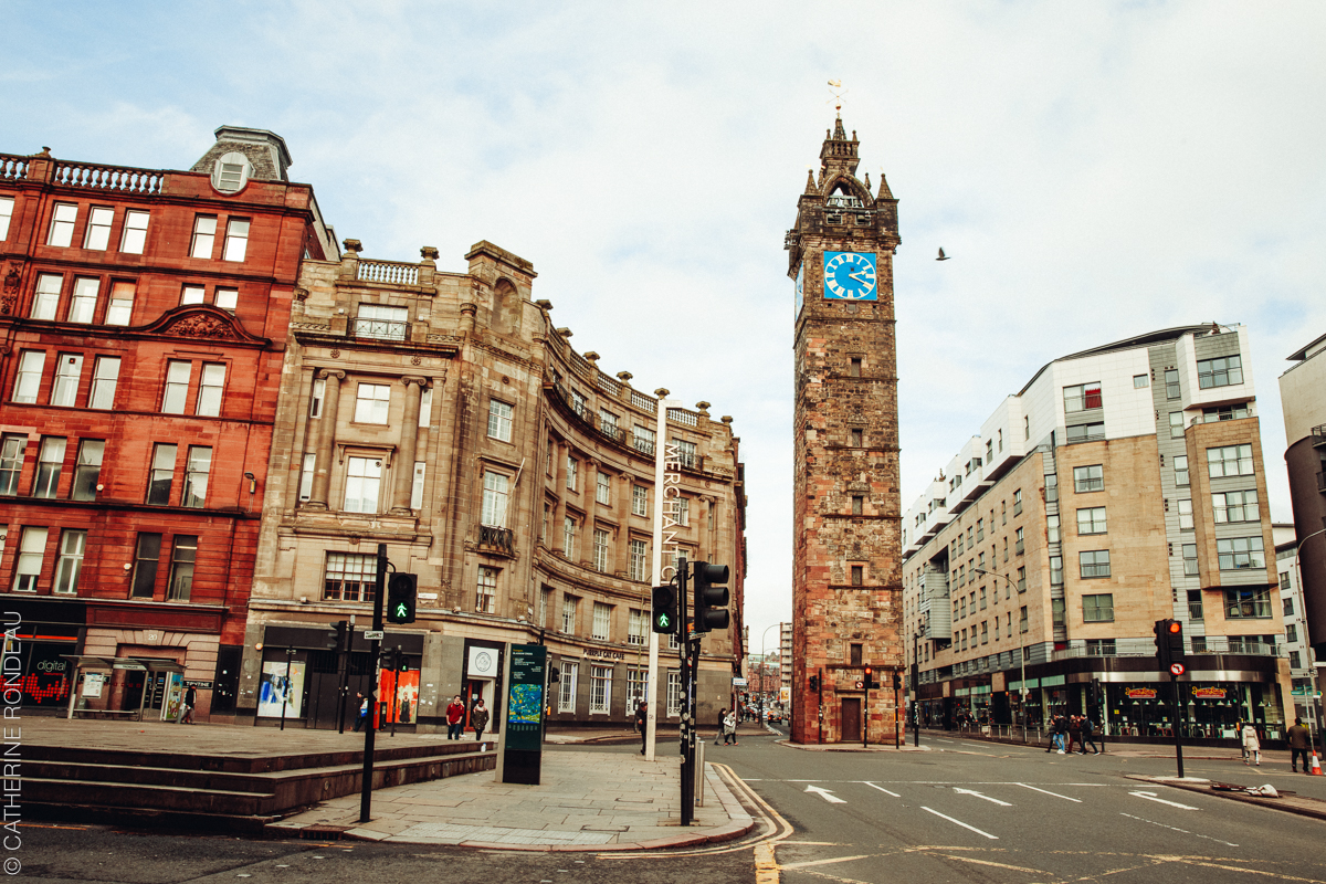 Street intersection dominated by tall clock tower.