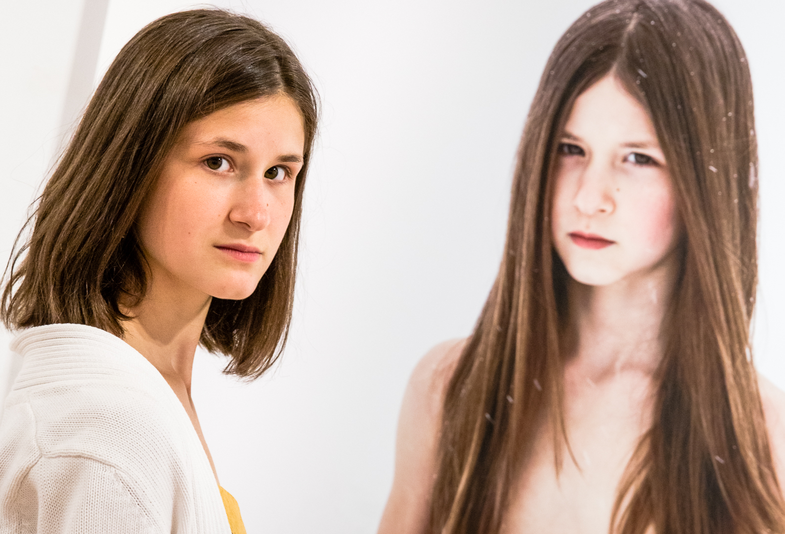 teenage photo model Emma Boudou takes the pose next to a large scale framed portrait of herself