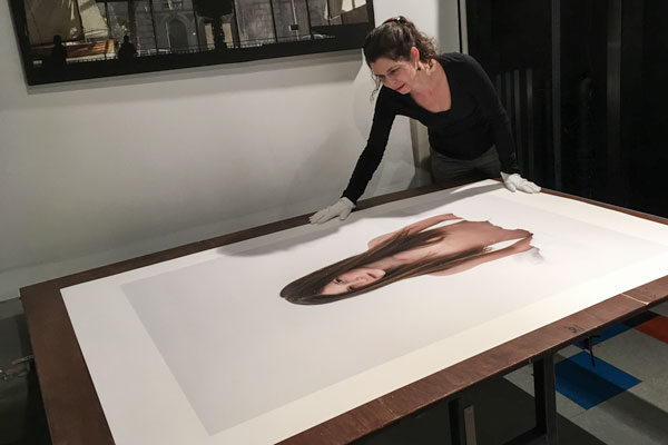 l&#039;artiste photographe Catherine Rondeau examine un tirage haut de gamme d&#039;une de ses oeuvres sur une table