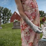 Photo montage of a child&#039;s torso in a cemetery with a little angel
