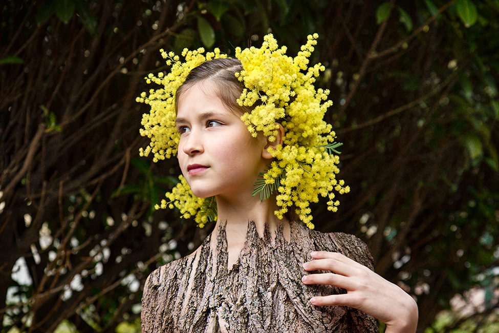 Portrait photo surréaliste d'une enfant coiffée de mimosas et au corp en écorce d'arbre