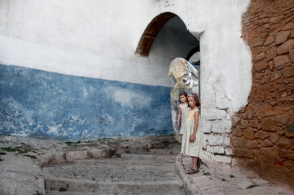 Photo montage of two children standing under a ghost-like figure