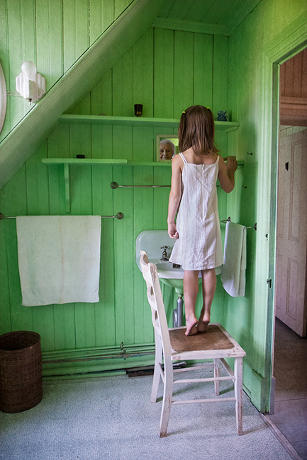 Photo montage of a child standing on a chair looking into a miroir