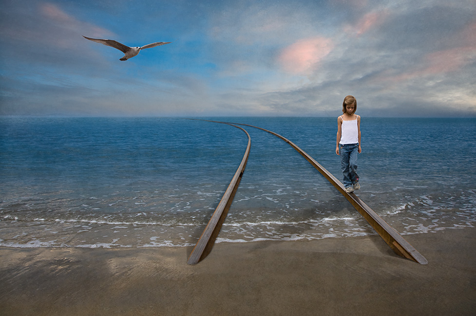 Photo montage of a child walking on a railway track floating on the ocean
