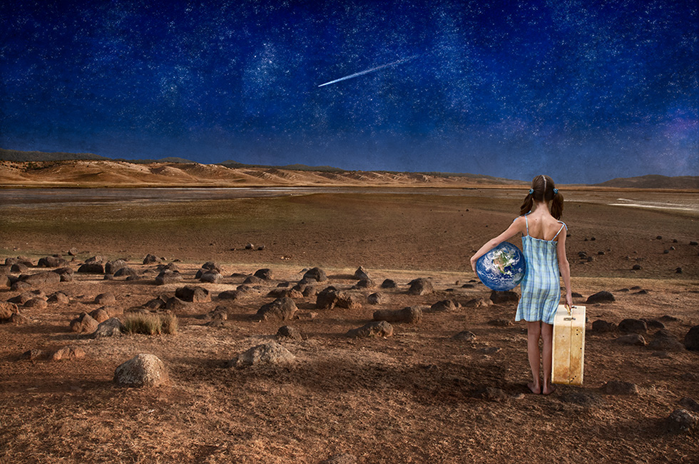 Photo montage of a child standing holding planet Earth under a starry night