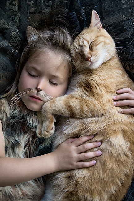 Photo montage d'une enfant métamorphosée en chat aux côté d'un chat roux