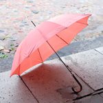 un parapluie rose ouvert est posé sur le sol