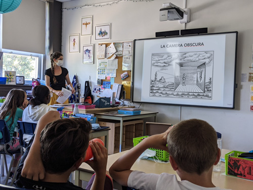 Photo of a woman speaking in front of a class in an elementary school