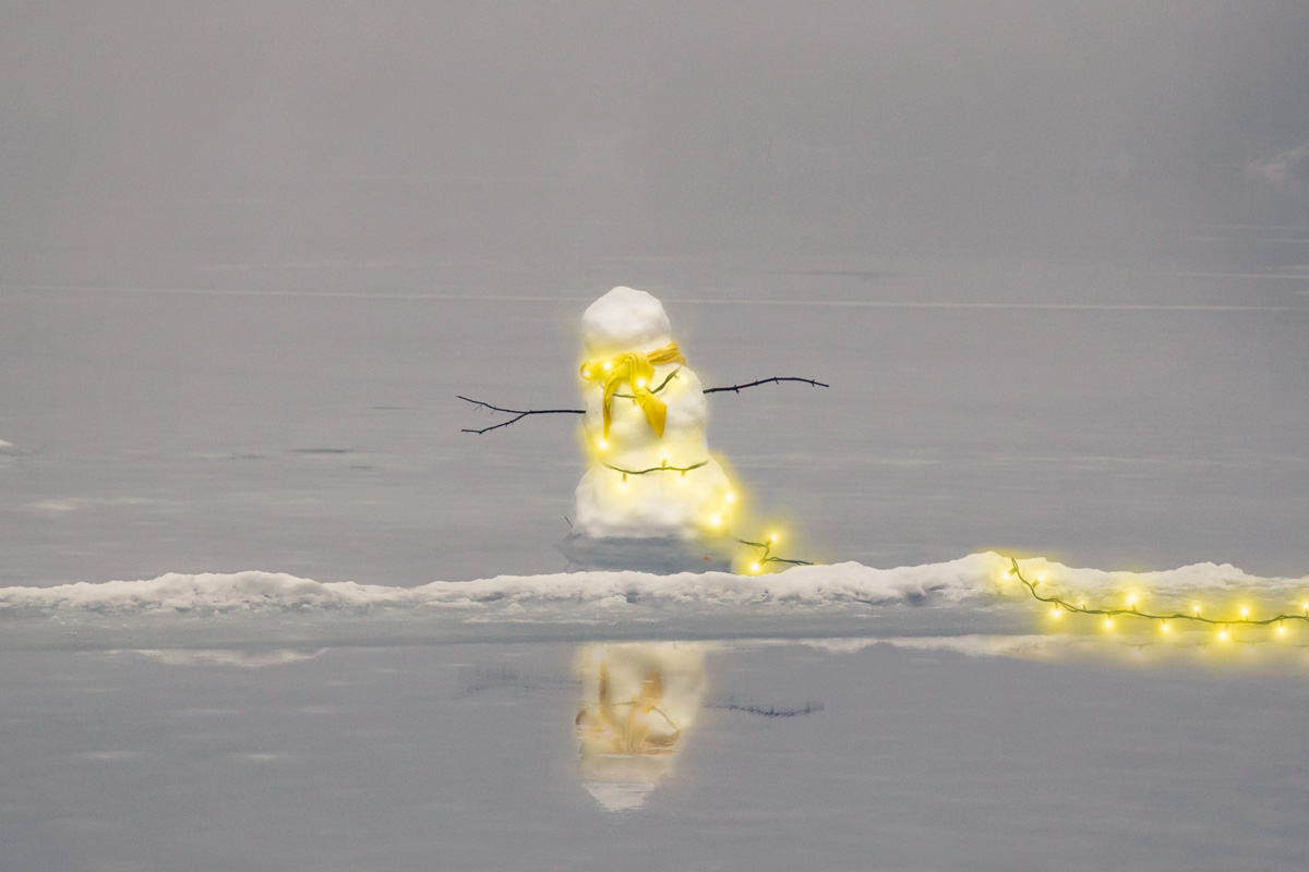 photomontage d'un bonhomme de neige entouré de lumière de noel