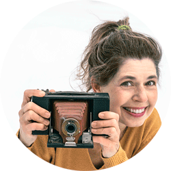 catherine-rondeau-artiste-arts-visuels-2025-250px Photographie de l'artiste Catherine Rondeau tenant un vieil appareil photo dans ses mains.