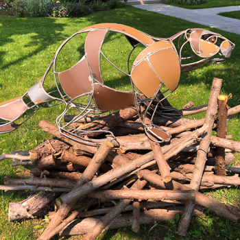 03_ma-ville-mon-quartier-ma-rue-2025 Sculpture en métal d'un castor sur un tas de bois.