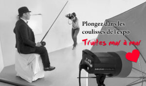 Studio photo avec un flash et parapluie à l'avant plant, un modèle à gauche qui tient une canne à pêche, une photographe regarde dans son appareil photo à l'arrière plan. Le texte suivant apparaît en surimpression : Plongez dans les coulisses de Truites mur à mur.