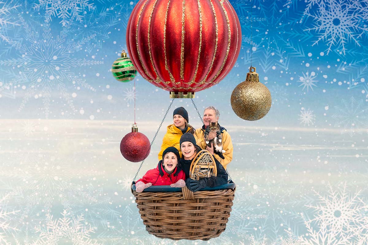 Photomontage surréel de 4 personnes dans un panier suspendu à une boule de Noël en guise de montgolfière dans le ciel.